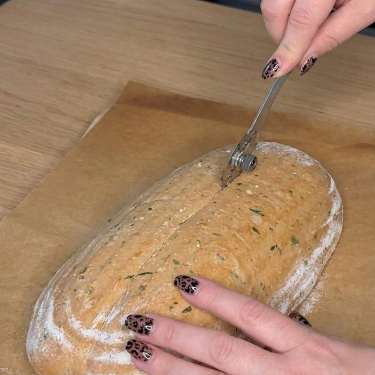 Scoring the Tomato Basil Sourdough Bread loaf with a blade, step 5 showing the cut that helps the dough expand properly during baking